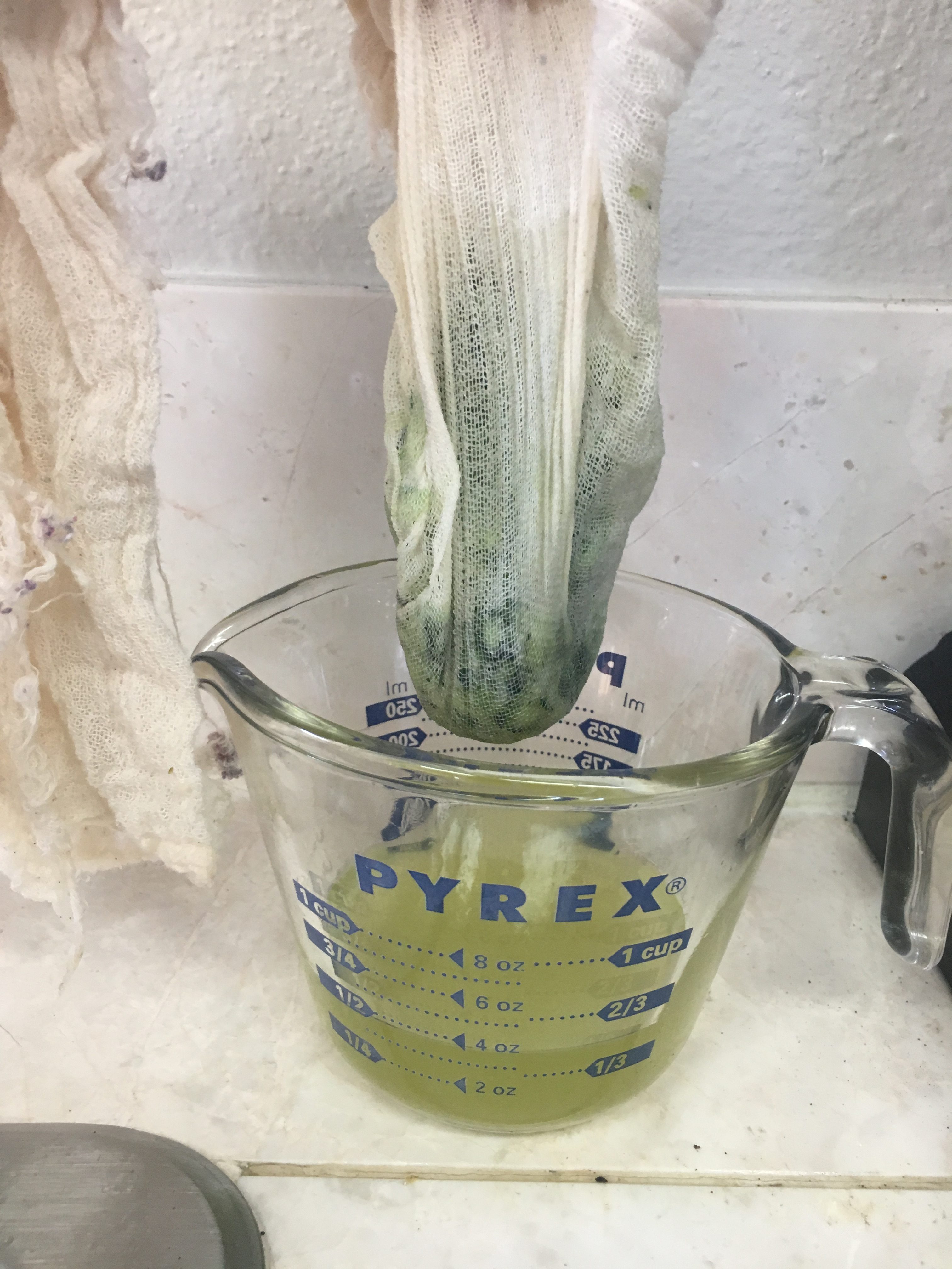 Zucchini in cheesecloth draining into measuring cup 