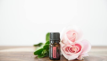 doTERRA Passion essential oil with pink rose in the background  