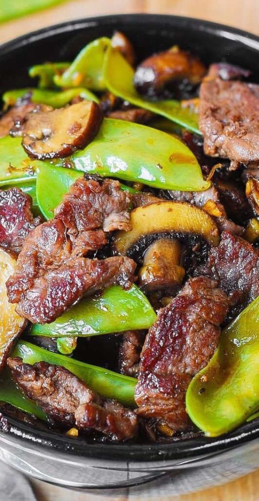 Asian Beef with Mushrooms and Snow Peas is a simple dinner perfect for those busy weeknights! Your family will love tender mushrooms, crisp snow peas, and thinly sliced sirloin steak sautéed with garlic.