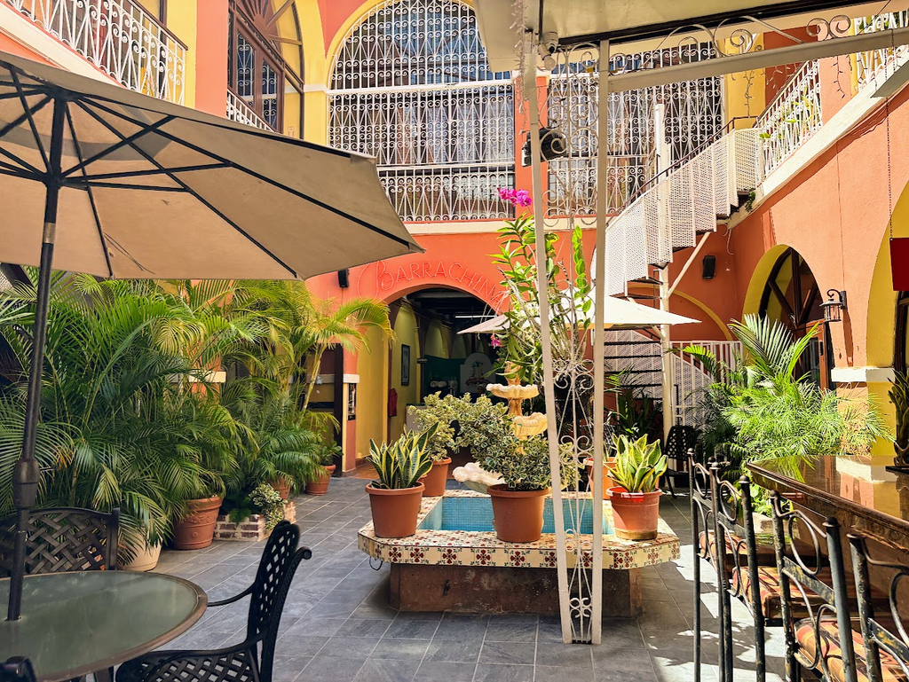 Frosted glass of Piña Colada topped with a cherry in the lush open-air courtyard at Barrachina in San Juan.